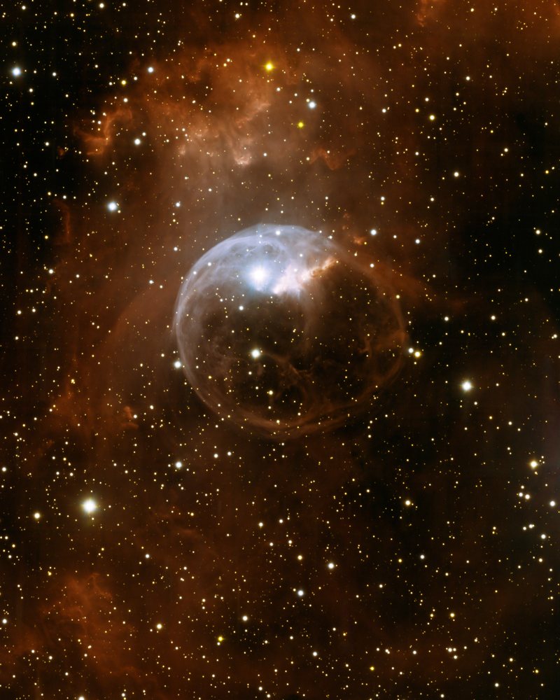 La nébuleuse de la Bulle, NGC 7635 : une sphère de gaz bleutée entourée de nuages orangés et d'étoiles.